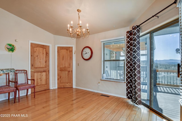 interior space with a mountain view, a notable chandelier, and light hardwood / wood-style flooring