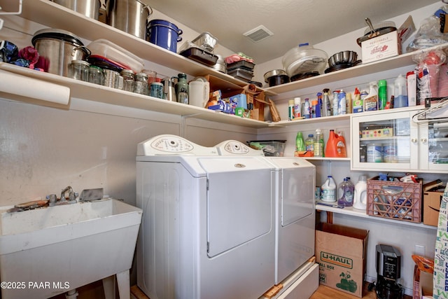 washroom with separate washer and dryer and sink