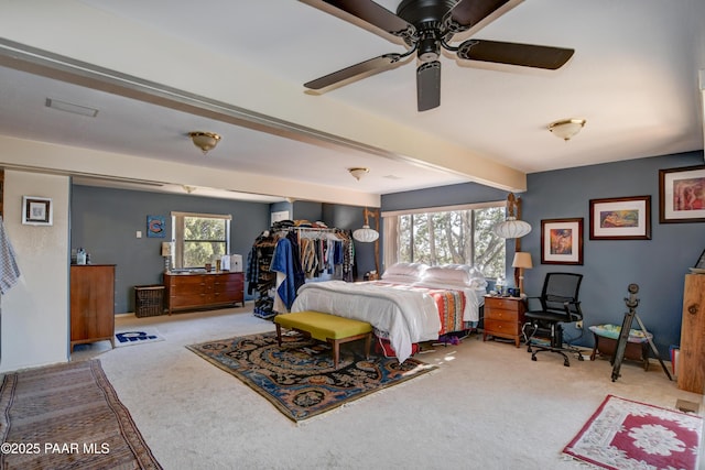 bedroom with beamed ceiling, carpet, and ceiling fan