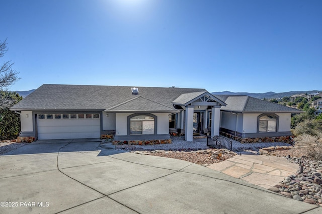 ranch-style home with a garage and a mountain view