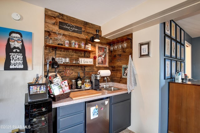 bar featuring wine cooler, sink, wooden walls, and stainless steel refrigerator