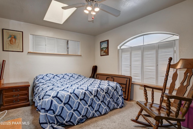 carpeted bedroom with a skylight and ceiling fan