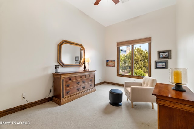 living area featuring light colored carpet and ceiling fan