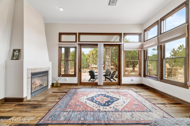 interior space with a tile fireplace and light hardwood / wood-style flooring