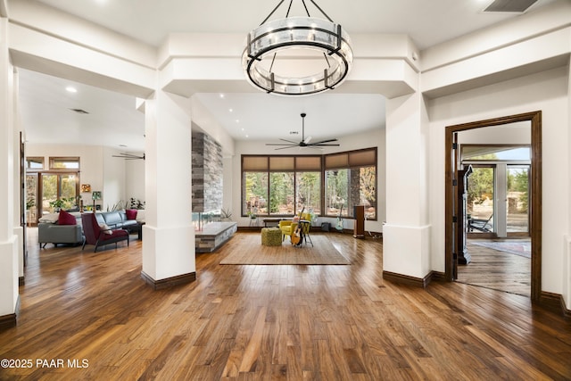 interior space featuring a wealth of natural light, wood-type flooring, and ceiling fan with notable chandelier