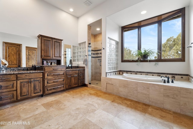 bathroom featuring vanity, plus walk in shower, and a high ceiling