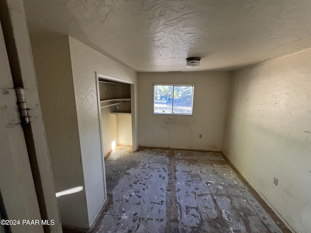 unfurnished bedroom featuring a closet and a textured ceiling