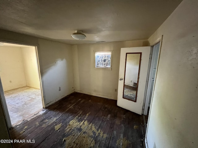 unfurnished room featuring dark wood-type flooring