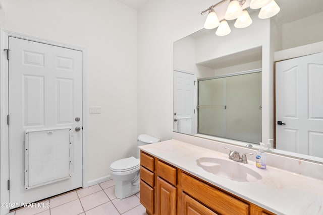 full bathroom featuring vanity, a shower with door, toilet, tile patterned floors, and a notable chandelier