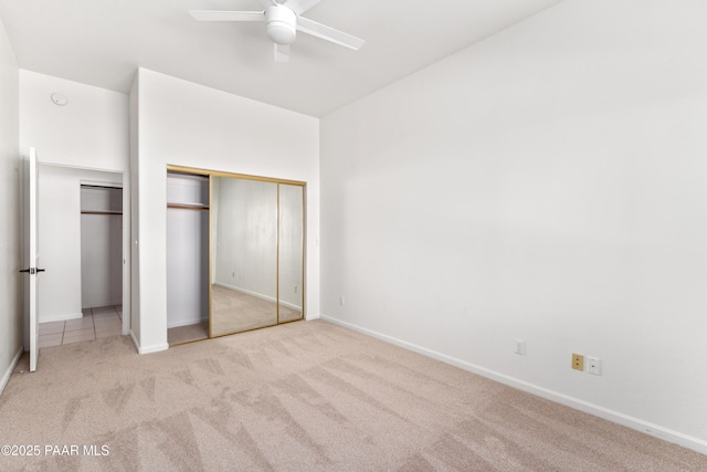 unfurnished bedroom with baseboards, multiple closets, and carpet