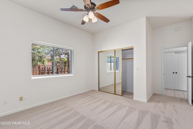 unfurnished bedroom with baseboards, carpet flooring, ceiling fan, and a closet