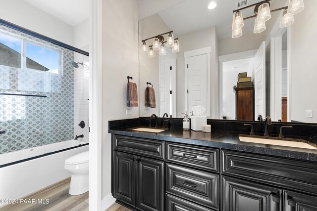 full bathroom featuring toilet, double vanity, and a sink