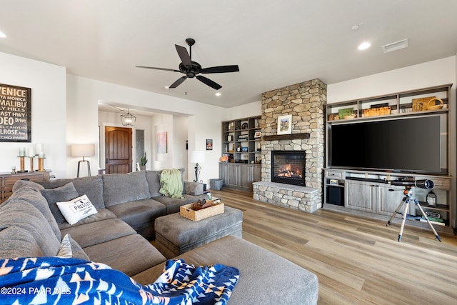 living room featuring recessed lighting, visible vents, a ceiling fan, a stone fireplace, and wood finished floors