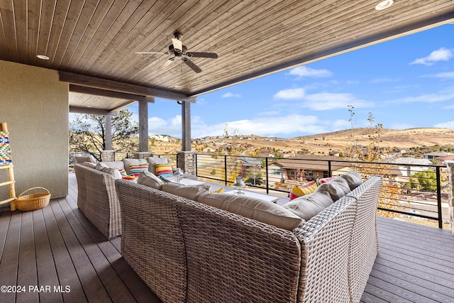 wooden deck featuring an outdoor hangout area, ceiling fan, and a mountain view