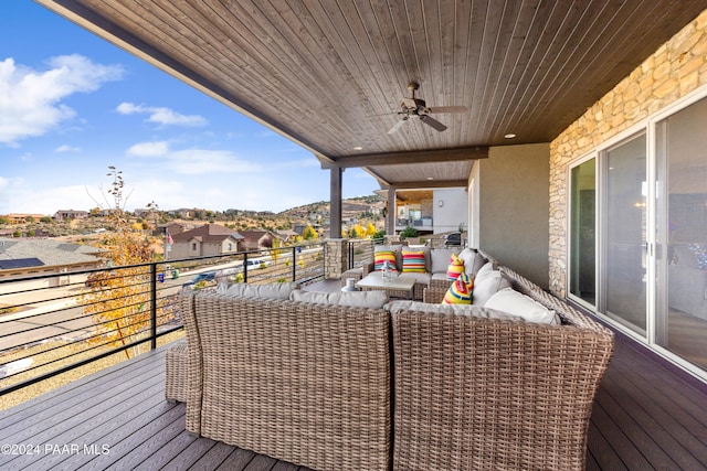 wooden terrace featuring a ceiling fan and an outdoor living space