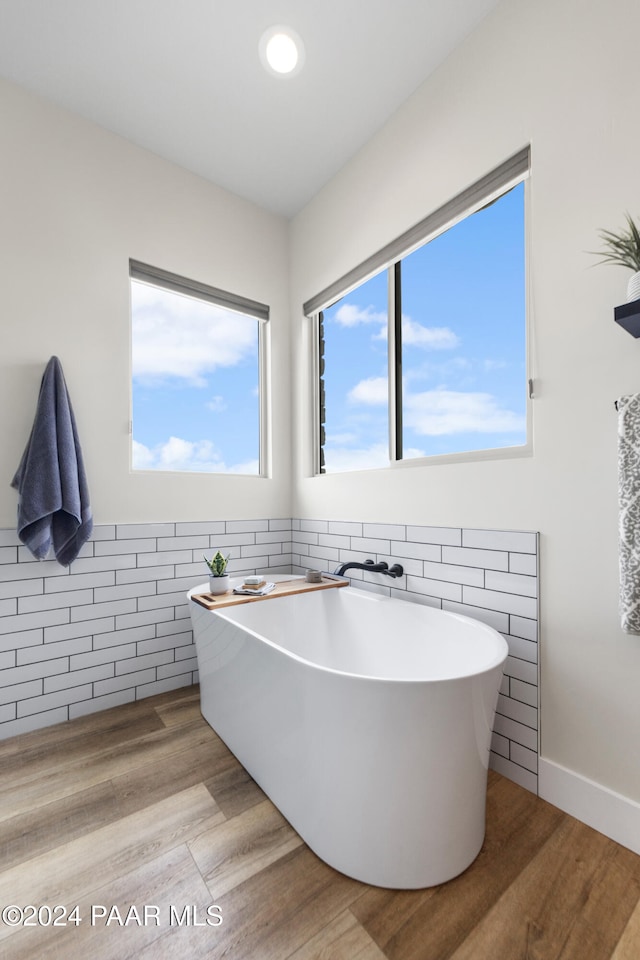 bathroom featuring a soaking tub and wood finished floors