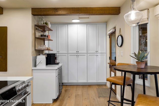 kitchen with pendant lighting, white cabinets, electric stove, beam ceiling, and light hardwood / wood-style floors