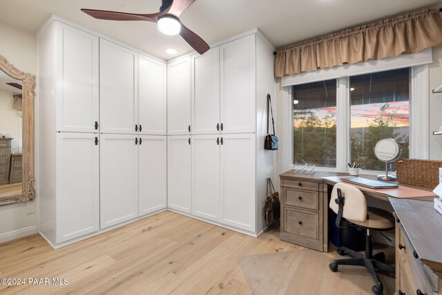 home office with light hardwood / wood-style floors and ceiling fan