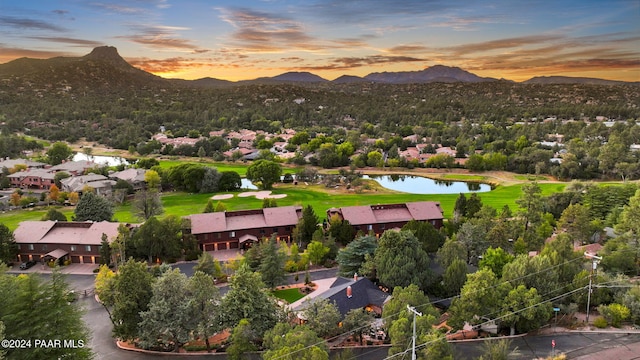 aerial view at dusk featuring a water and mountain view