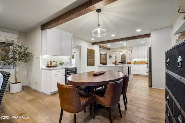 dining space featuring beamed ceiling, light hardwood / wood-style floors, and wine cooler