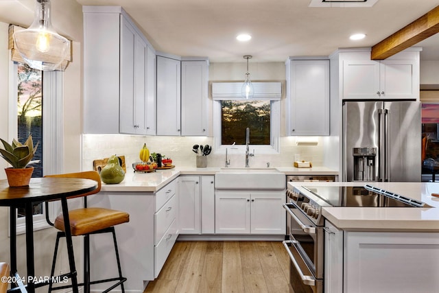 kitchen featuring white cabinets, hanging light fixtures, and appliances with stainless steel finishes