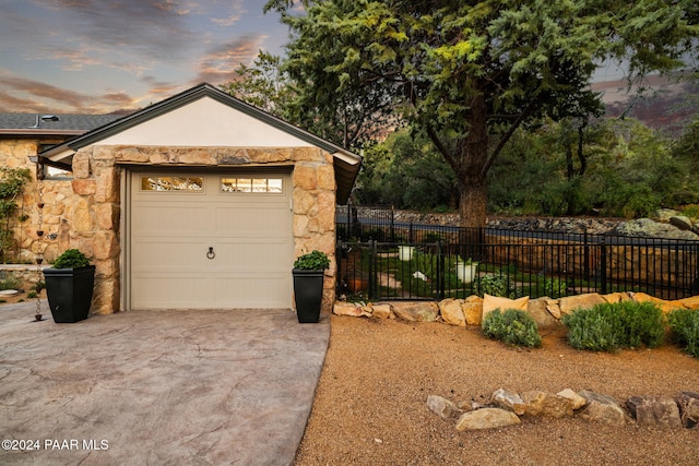 view of garage at dusk