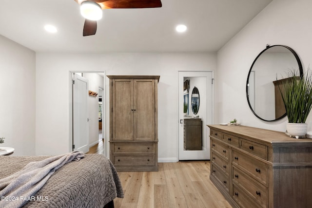 bedroom with light wood-type flooring, ceiling fan, and connected bathroom