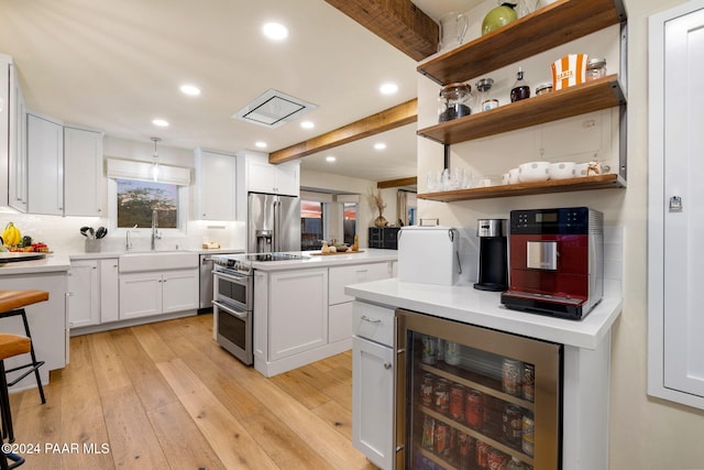 kitchen with white cabinetry, sink, wine cooler, light hardwood / wood-style floors, and appliances with stainless steel finishes