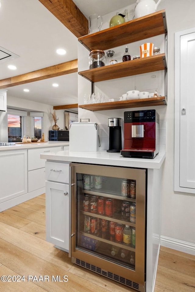 bar featuring white cabinetry, wine cooler, and light hardwood / wood-style floors