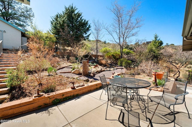 view of patio with outdoor dining space and stairs