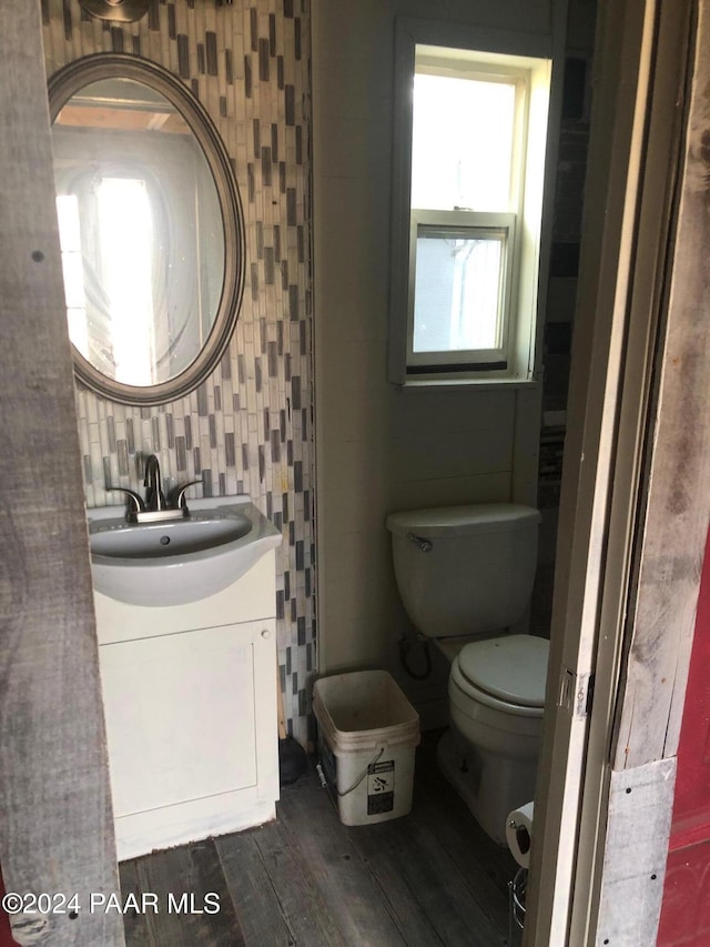 bathroom with decorative backsplash, toilet, vanity, and hardwood / wood-style flooring