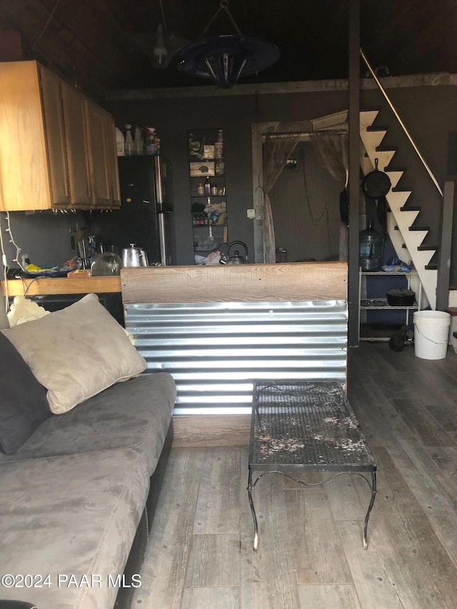 interior space featuring hardwood / wood-style flooring and black fridge