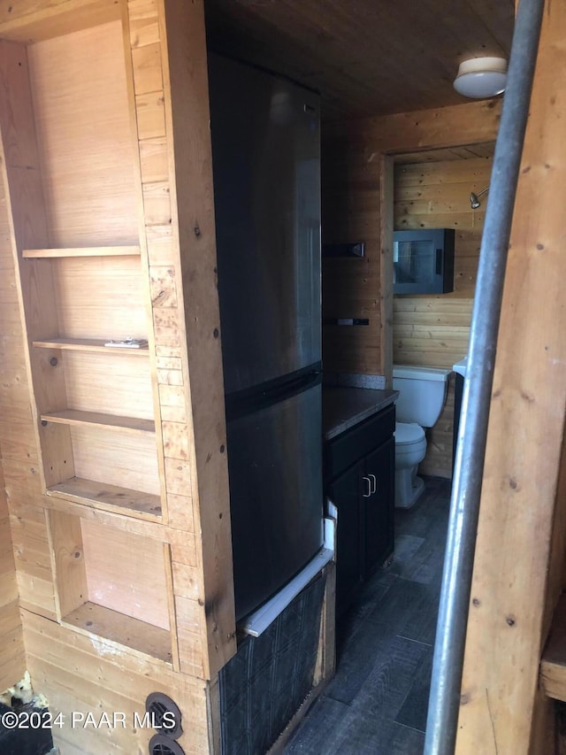 bathroom featuring toilet, wood ceiling, and wooden walls