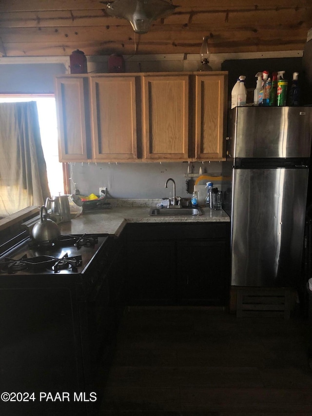 kitchen featuring gas stovetop, stainless steel refrigerator, and sink