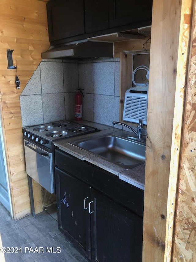 kitchen with decorative backsplash, light hardwood / wood-style floors, sink, and stainless steel gas range