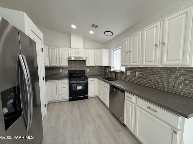 kitchen with dark countertops, visible vents, under cabinet range hood, appliances with stainless steel finishes, and a sink