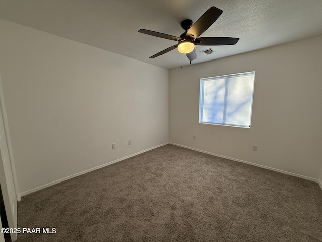 unfurnished room featuring dark colored carpet, visible vents, baseboards, and ceiling fan