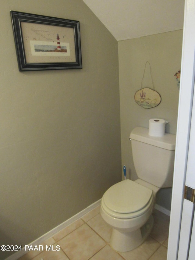 bathroom with tile patterned flooring, toilet, and lofted ceiling