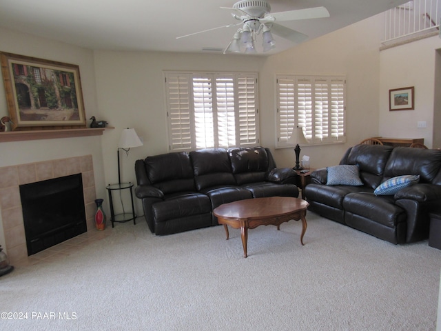 living room featuring carpet, ceiling fan, and a tiled fireplace