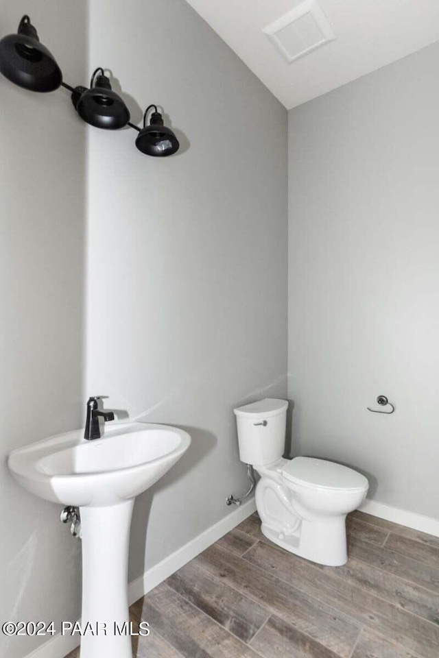 bathroom featuring wood-type flooring and toilet