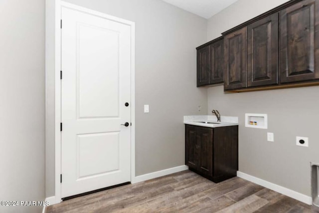 clothes washing area featuring cabinets, sink, washer hookup, light wood-type flooring, and hookup for an electric dryer