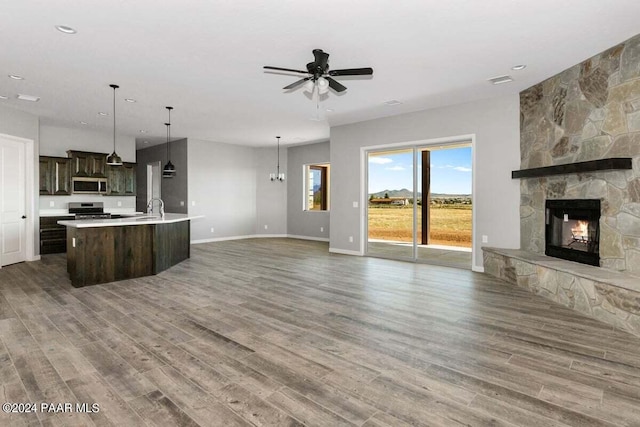 kitchen with hanging light fixtures, dark brown cabinetry, dark wood-type flooring, and appliances with stainless steel finishes