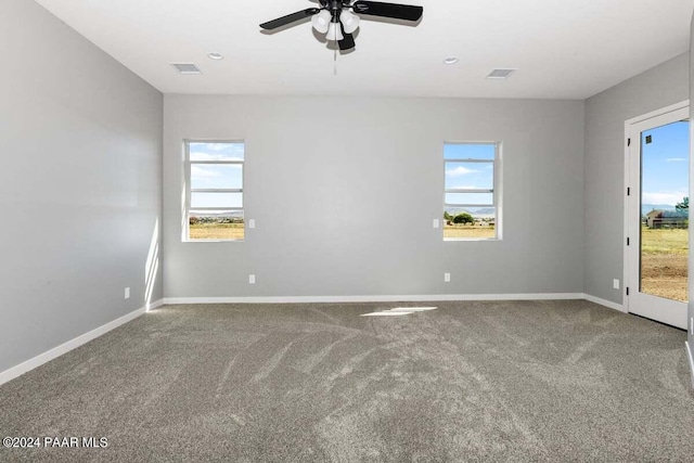 empty room with ceiling fan, carpet, and a healthy amount of sunlight