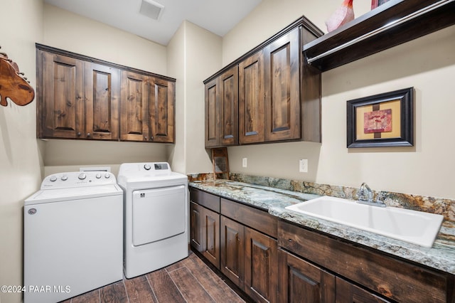 clothes washing area featuring dark hardwood / wood-style flooring, cabinets, independent washer and dryer, and sink