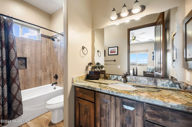 full bathroom featuring shower / bathtub combination with curtain, a wealth of natural light, ceiling fan, and toilet