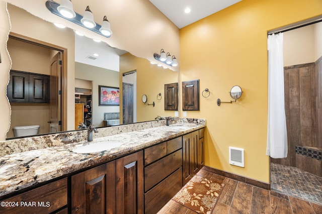 bathroom with radiator, a shower with curtain, wood-type flooring, toilet, and vanity