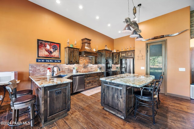 kitchen featuring dark brown cabinetry, sink, dark hardwood / wood-style flooring, a kitchen bar, and appliances with stainless steel finishes