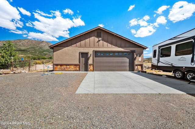 view of front facade featuring a mountain view, an outbuilding, and a garage