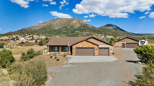 9757 N Heartland Dr, Prescott Valley, AZ 86315 - ranch-style house featuring concrete driveway, stone siding, a mountain view, and a garage