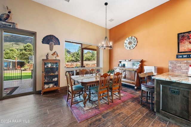 dining room with dark wood-type flooring and an inviting chandelier